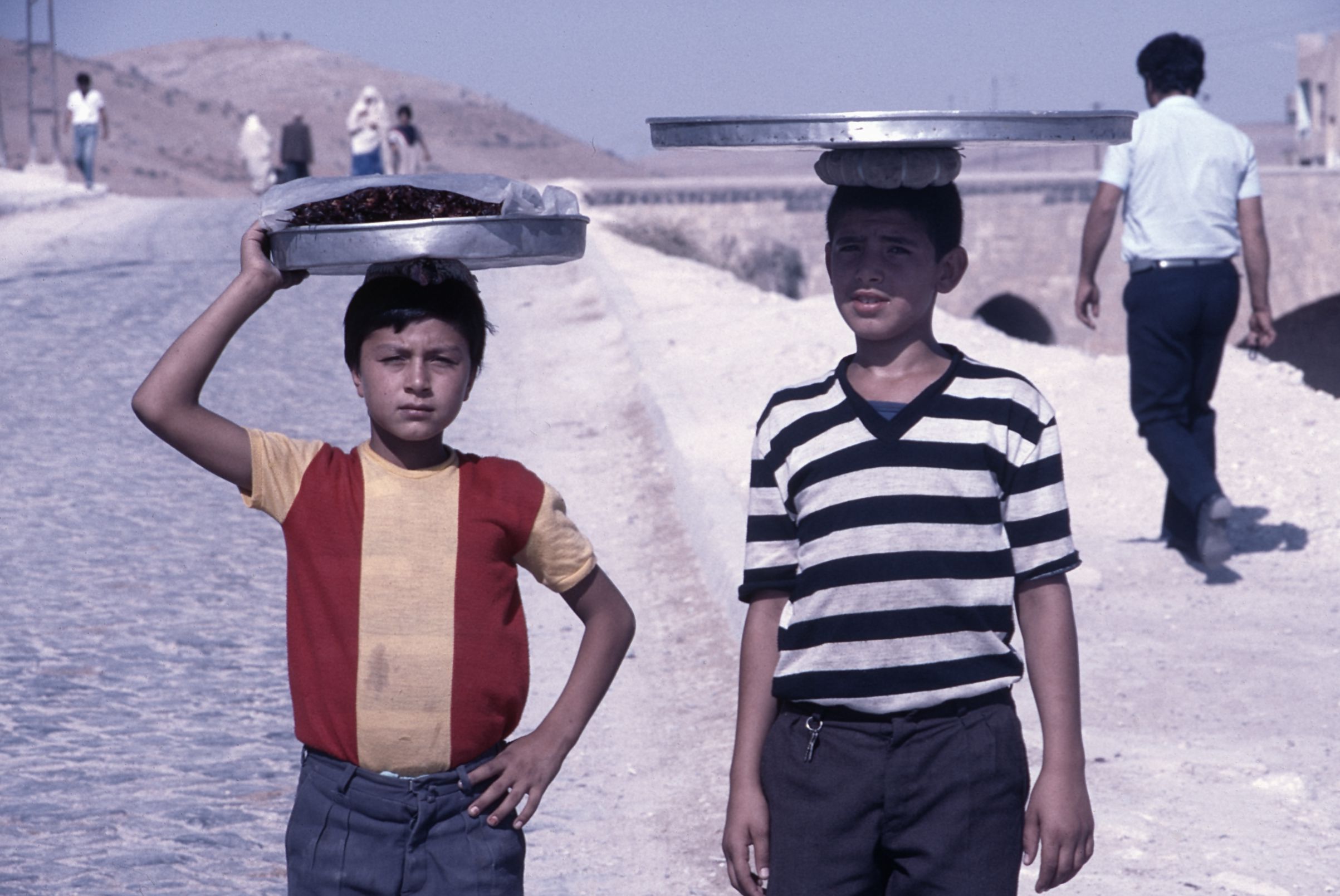 Two boys holding trays above their heads in Turkey in 1986